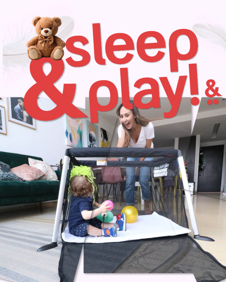 woman playing with toddler sitting in open sided travel cot - phil&teds traveller portable crib